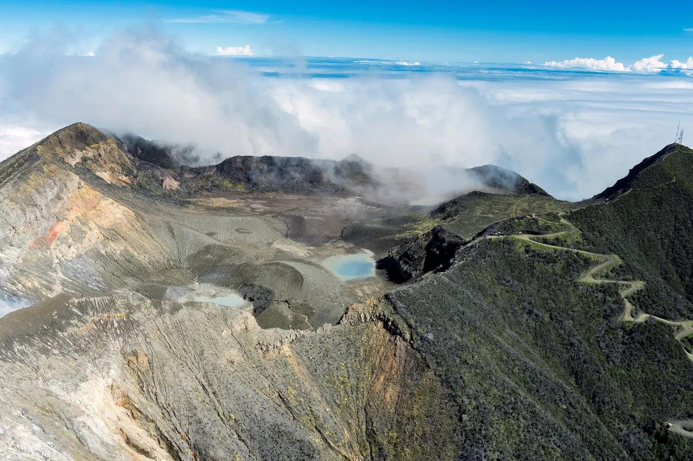 A stunning aerial shot of Turrialba Volcano in Costa Rica with clouds surrounding the crater.