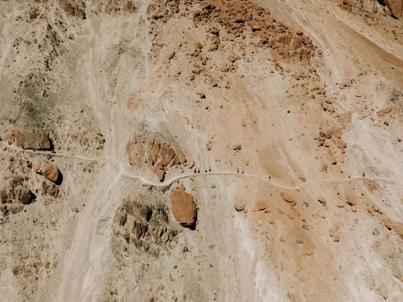 High-angle shot of a rocky mountain path in Ladakh, showcasing the arid landscape and a narrow trekking trail.