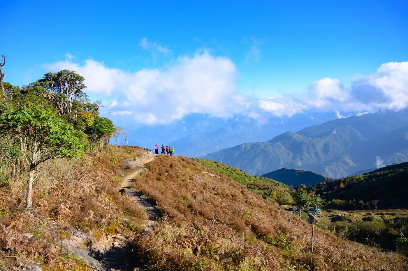 Hikers enjoying a scenic view on a mountain trail in Lào Cai, Vietnam.