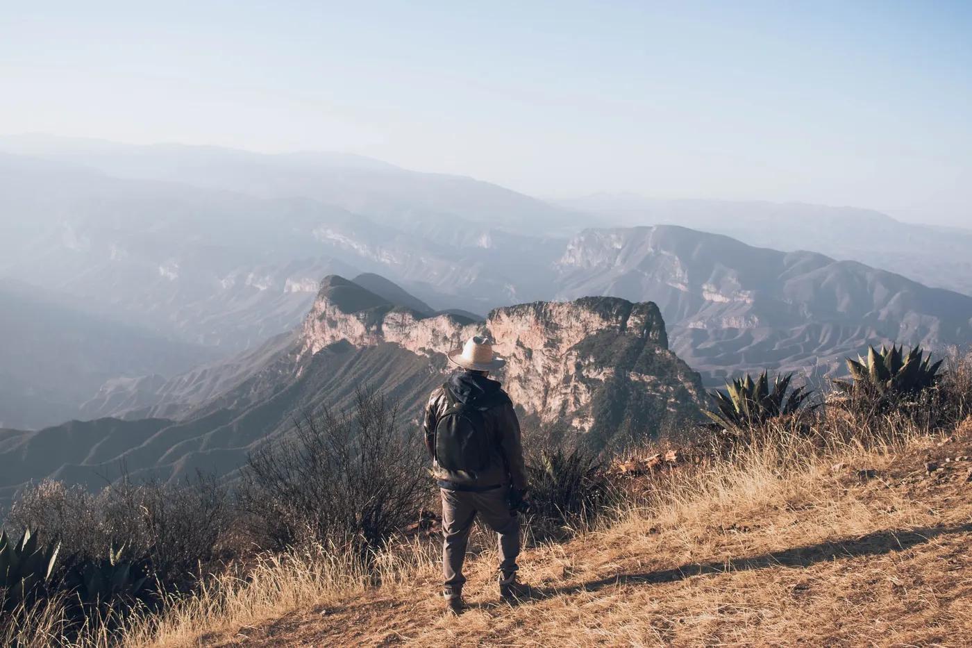 Back view of a hiker overlooking the scenic mountains of Pinal de Amoles, Mexico.