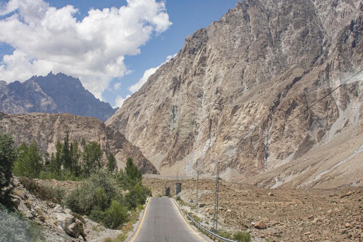 Breathtaking view of the rugged mountains in Hunza Nagar along a winding road under a clear blue sky.