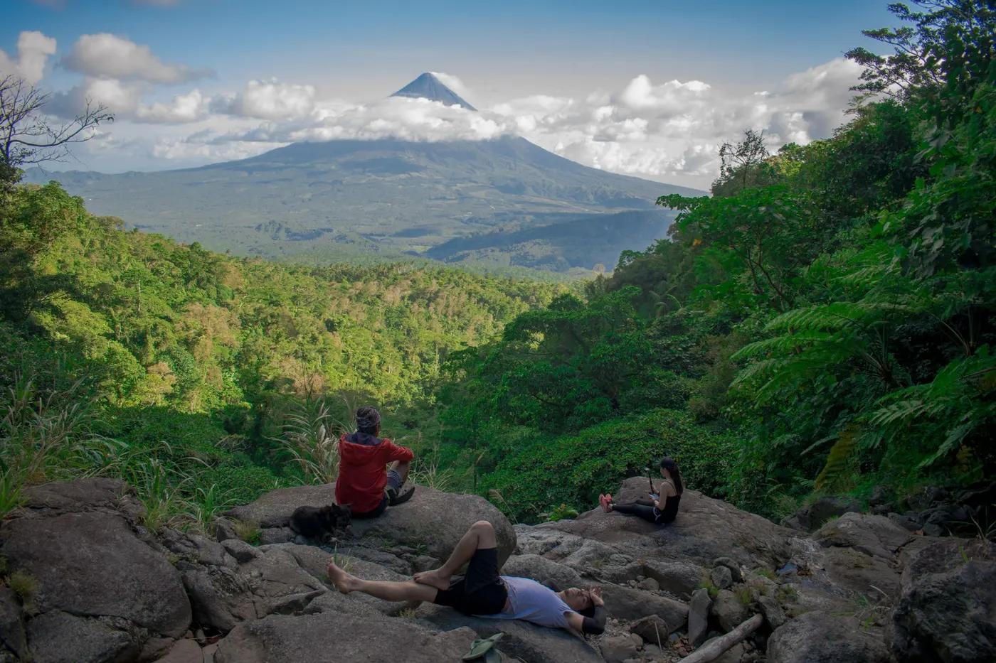 Hikers rest with a scenic view of Mayon Volcano in Bicol, Philippines.