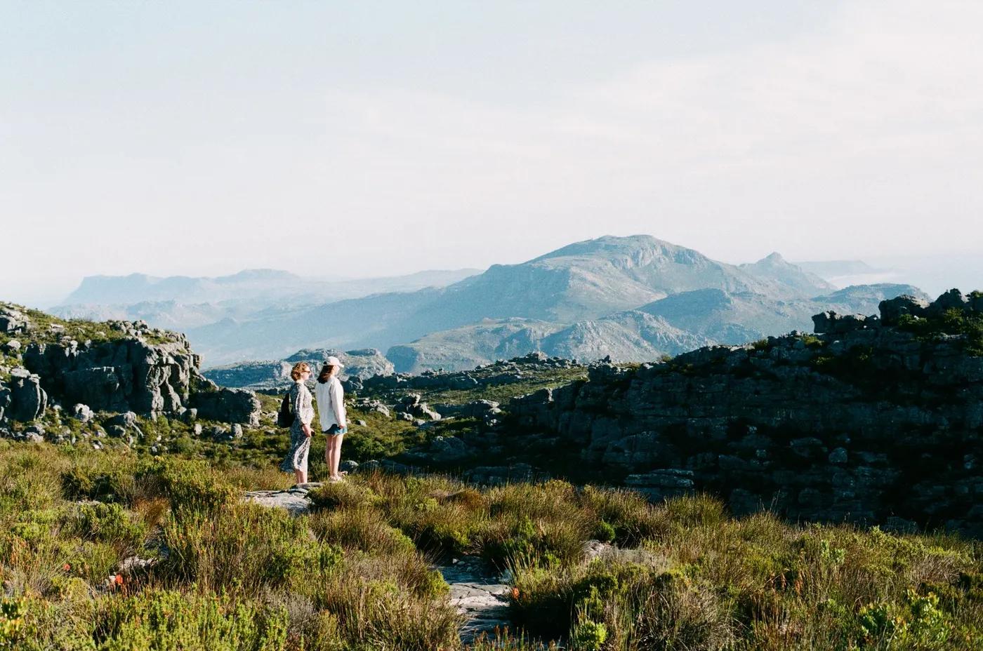 Two women enjoy a scenic hike in the breathtaking landscape of Cape Town, South Africa.