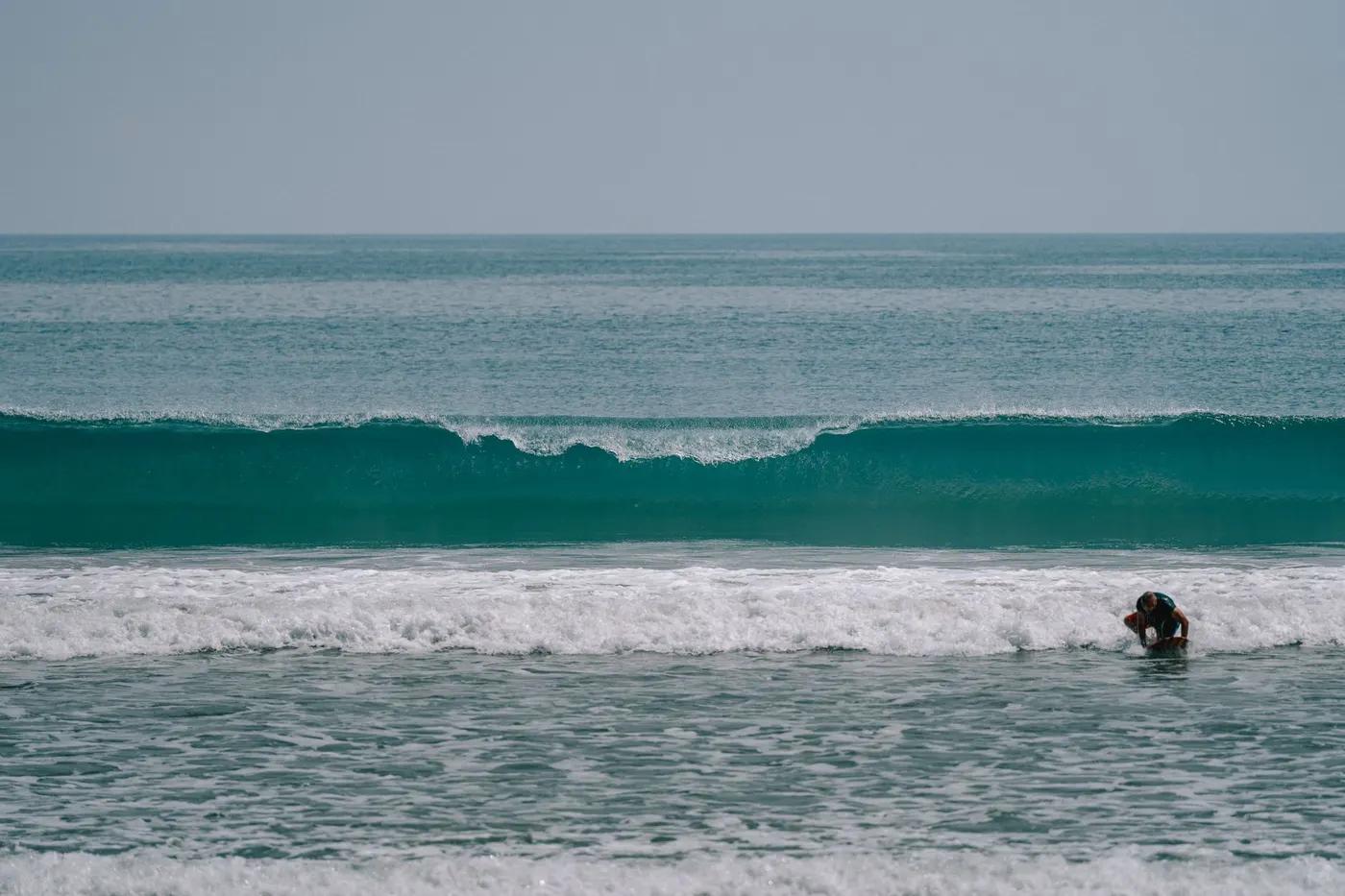 A surfer enjoys the waves at Kuta Beach in Bali, Indonesia, a popular surfing destination.