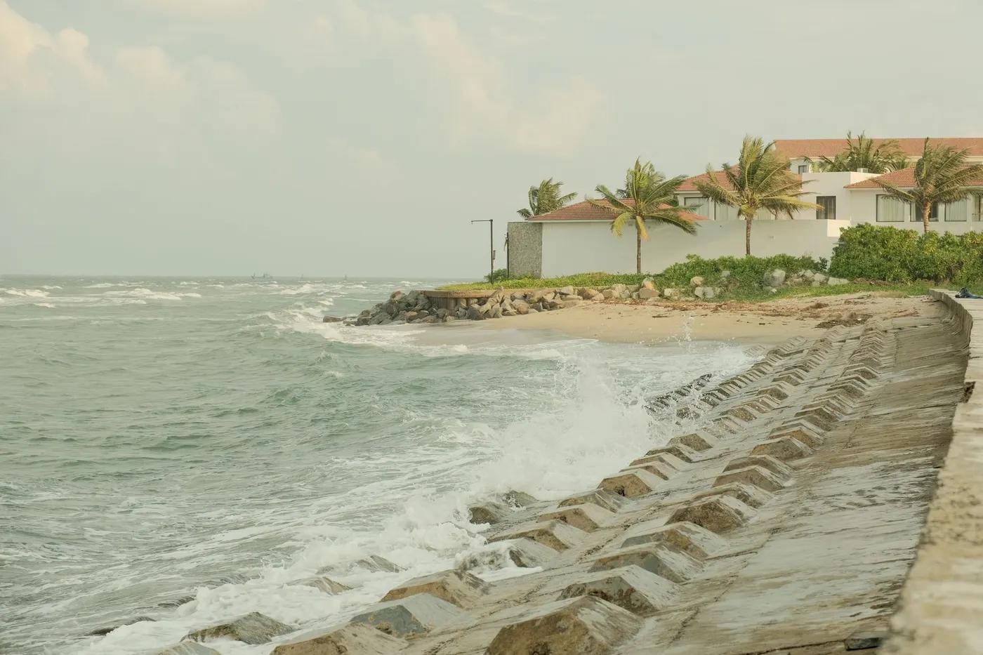 Beautiful coastal scene in Hội An, Vietnam showing waves crashing against the seawall.